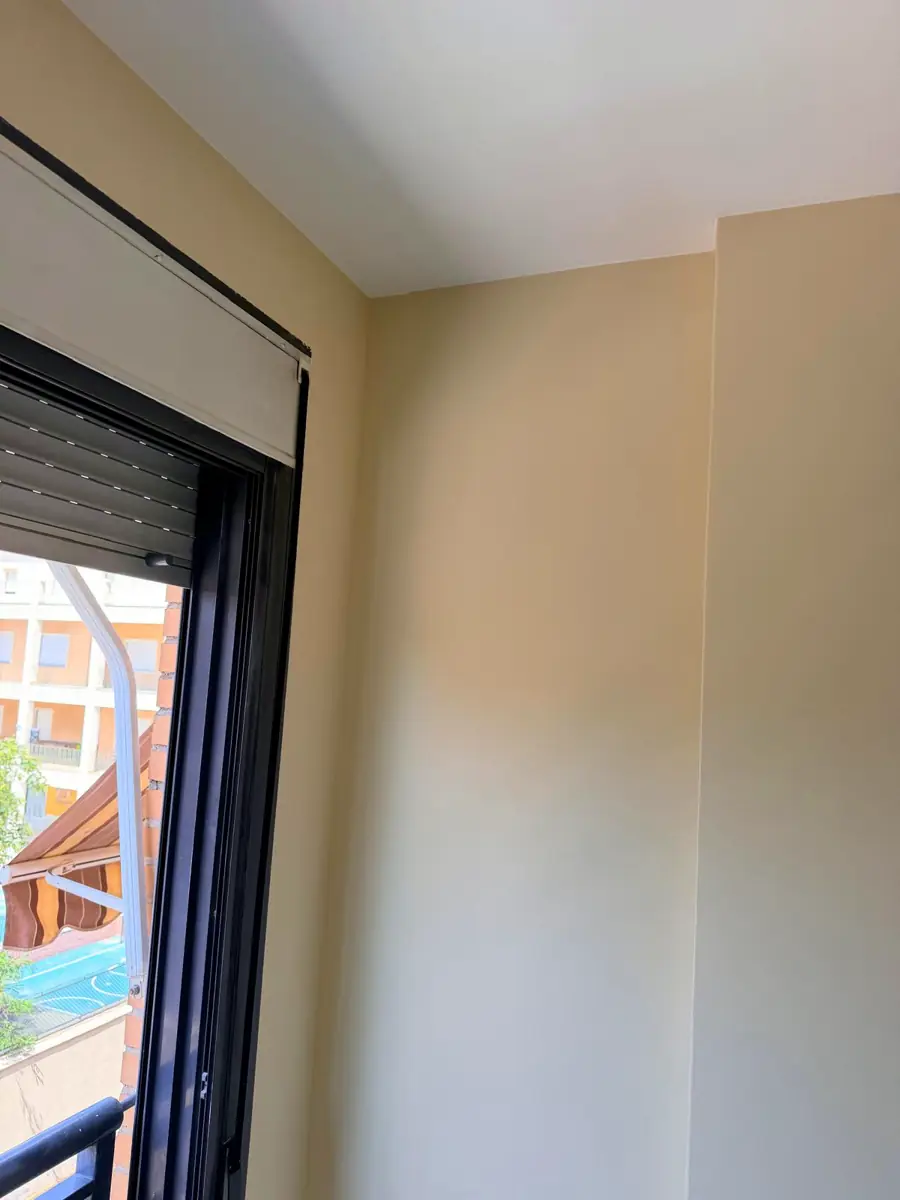 Dormitorio pintado en color crema con techo blanco