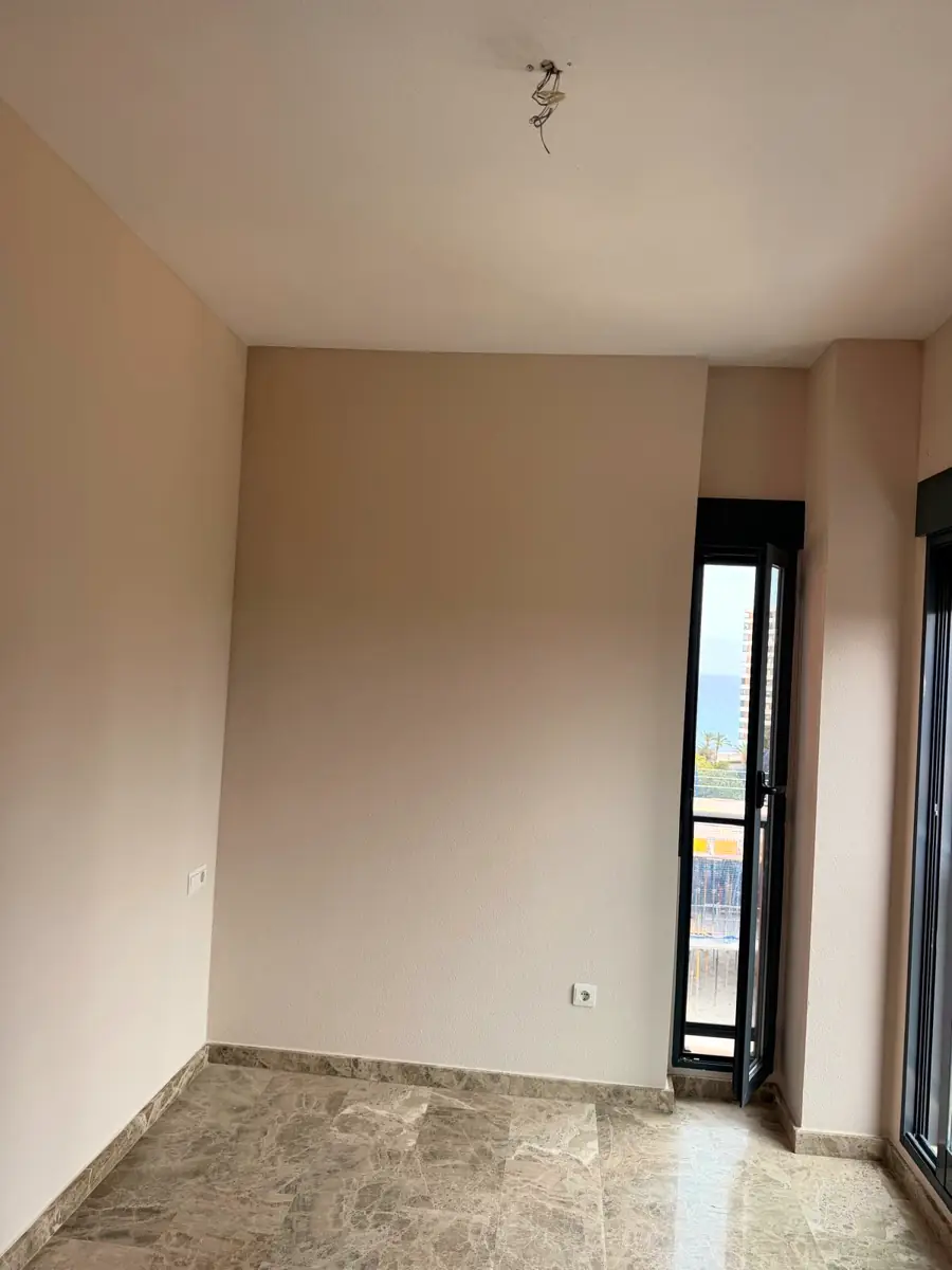 Dormitorio recién pintado con paredes lisas y acabado uniforme